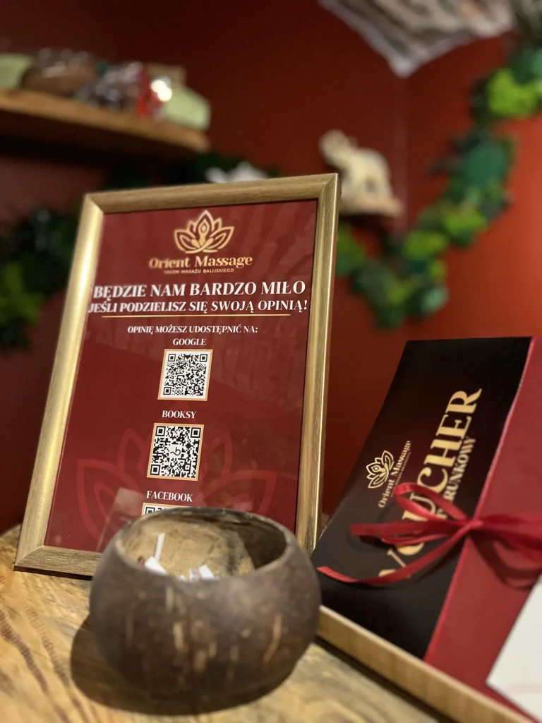 Ramka z kodami QR do wystawienia opinii obok voucherów na drewnianej ladzie.